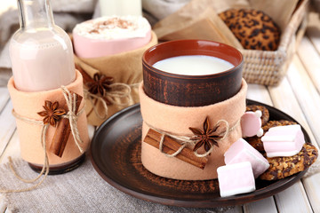 Mug of hot drink decorated in felt on wooden table