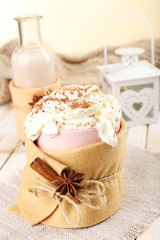 Mug of hot drink decorated in felt on wooden table