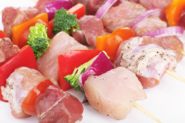 Raw pork kebab with vegetables close up
