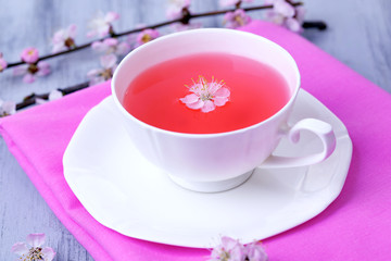 Fragrant tea with flowering branches on wooden table close-up