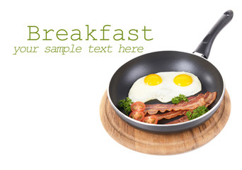 Scrambled eggs and bacon on frying pan isolated on white