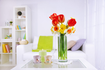 Beautiful spring flowers in vase on home interior background
