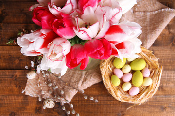 Composition with Easter eggs and beautiful tulips in glass jug