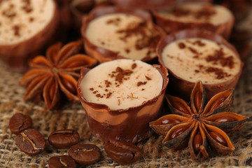Tasty chocolate candies with coffee beans and nuts, close up