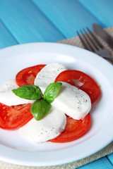Caprese salad with mozarella cheese, tomatoes and basil