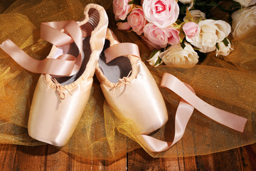 Ballet pointe shoes on wooden background
