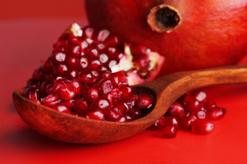 Ripe pomegranates on red background