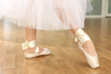 Ballerina legs in pointes in dancing hall