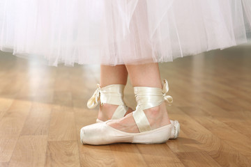 Ballerina legs in pointes in dancing hall © Africa Studio