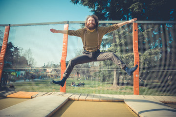 man jumping on trampoline at playground
