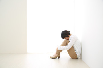 体育座りで悩む女性