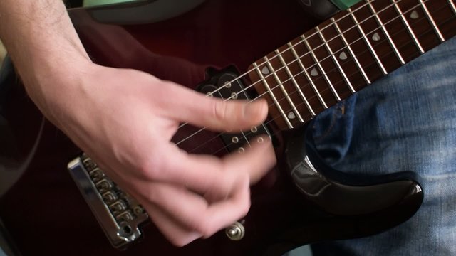Close up shot of a man playing guitar