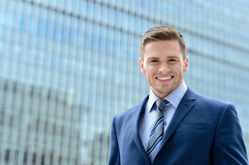 Smart young businessman looking at camera