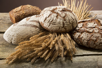 Brot und Getreide auf Holztisch - obrazy, fototapety, plakaty