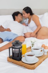Obraz na płótnie Canvas Affectionate couple having breakfast in bed