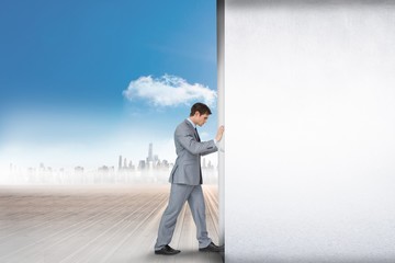 Fototapeta premium Composite image of businessman pushing away scene