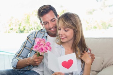 Loving couple with flowers and greeting card