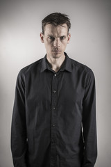 serious looking man on depressing grey background