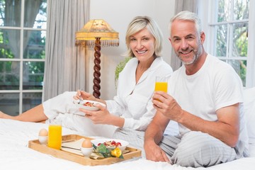 Mature couple having breakfast in bed