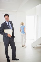 Well dressed real estate agent with blurred woman in background