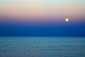 Plakaty  Księżyc, który o zmroku wznosi się nad błękitnym morzem