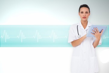 Composite image of pretty nurse using tablet pc
