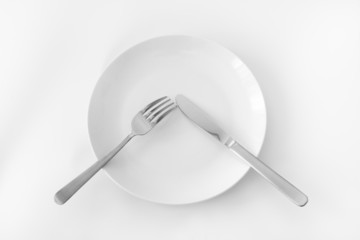 White plate with fork and knife.