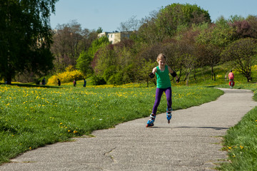 Fototapeta premium girl on inline skates learns to ride 