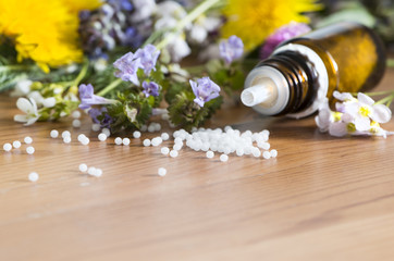 Blüten und Globuli auf Naturholz