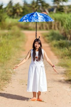 Young Thai girl balancing an umbrella on her head