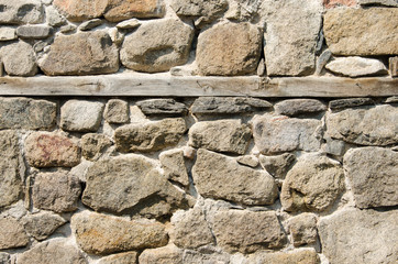 Wall of crushed stone, masonry and wooden plank