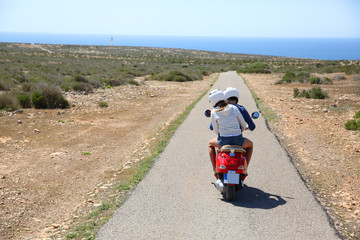 Back view of couple riding moto in natural landscape