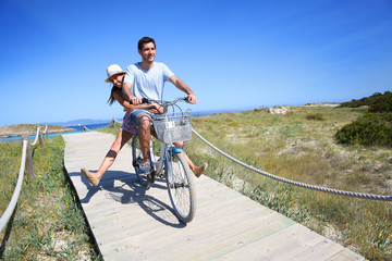 Man giving bike ride to girlfriend on beautiful Island