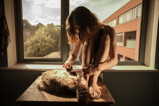 Woman and cat by the window