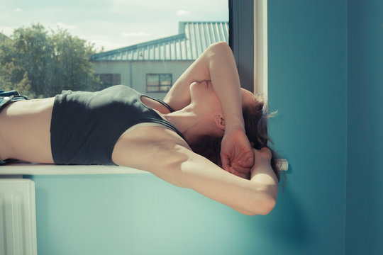 Young woman lying in window