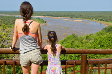 Mother and daughter looking at river, tourists in South Africa