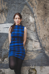 Pretty girl posing against a concrete wall
