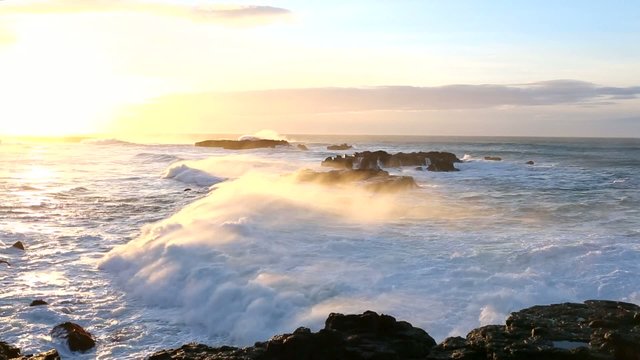 Strong sea surf in the rays of the rising sun