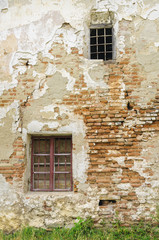 Fototapeta na wymiar Windows with iron bar grill in stone wall