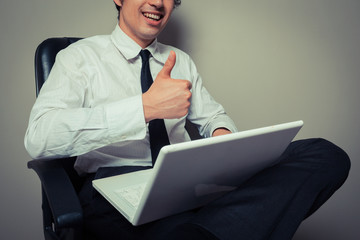 Businessman in office chair giving thumbs up