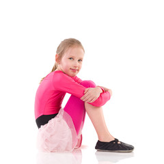 Little girl sitting on the floor, Side view.