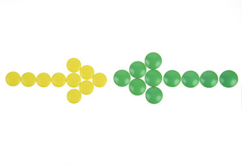 Arrow of yellow and green pills on white background