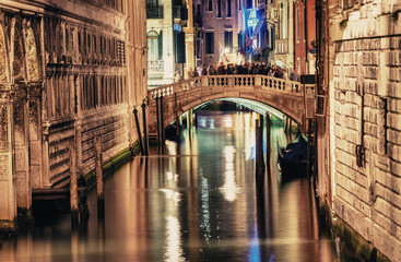Fototapeta na wymiar VENICE, ITALY - MAR 23, 2014: Bridge of Sighs at night with tour