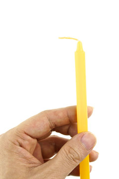Hand hold yellow candle for lit isolated