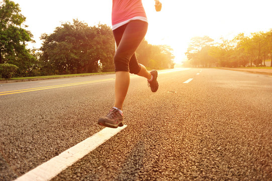 fitness woman runner athlete running on sunrise road