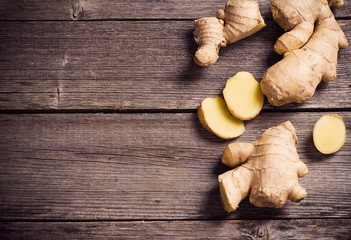 Ginger root sliced on wooden background
