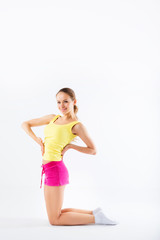 Young woman doing aerobics and stretching, isolated on white bac