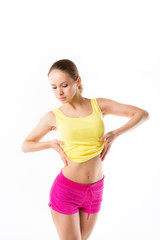 Fototapeta premium Happy young woman with beautiful slim body in yellow sport cloth