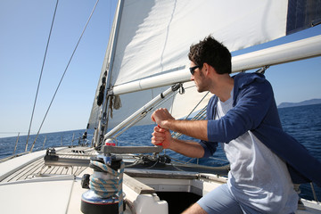 Naklejka premium Man sailing with sails out on a sunny day