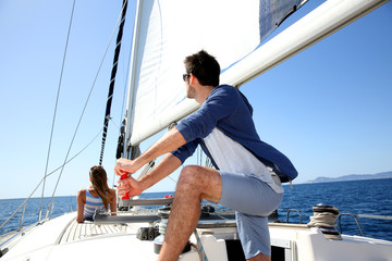 Skipper on sailboat navigating in mediterranean sea
